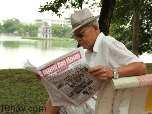 Một ông cụ đọc báo Người lao động bên hồ Gươm